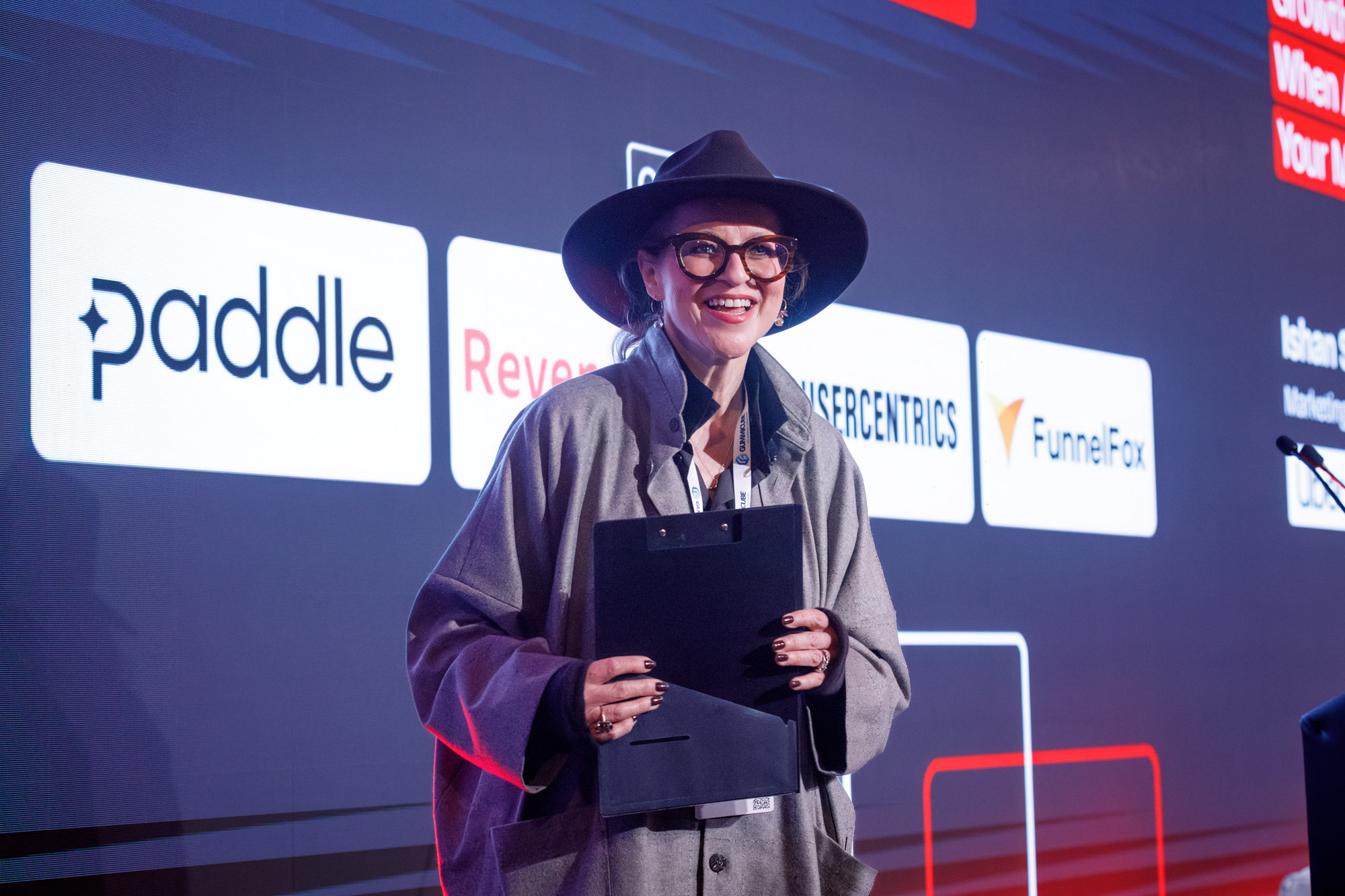 Jacki Vause smiling on stage with her presentation notes